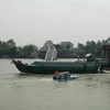 Lực lượng chức năng đang áp tải tàu dưới 300 tấn qua cầu Ghềnh. (Ảnh: Sỹ Tuyên/Vietnam+)