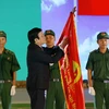 Chủ tịch nước Trương Tấn Sang trao Huân chương Độc lập hạng B lên lá cờ truyền thống của Lực lượng Thanh niên Xung phong TP.Hồ Chí Minh. (Ảnh: Thanh Vũ/TTXVN)