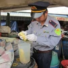 Lực lượng chức năng tiến hành niêm phong số măng có chứa chất vàng ô tại hộ kinh doanh của bà Trần Thị Xuân ở chợ Đông Hà. (Ảnh: Thanh Thủy/TTXVN)