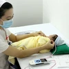 Nhân viên y tế sàng lọc khiếm thính cho sơ sinh tại Trung tâm Sàng lọc – chẩn đoán trước sinh và sơ sinh. (Ảnh: Dương Ngọc/TTXVN)