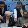 Chủ tịch Hội đồng Hòa bình tối cao Afghanistan Pir Sayed Ahmed Gailani (trái, trước) và đại diện của thủ lĩnh Gulbuddin Hekmatyar, ông Amin Karim (phải) sau lễ ký thỏa thuận hòa bình ở Kabul ngày 22/9. (Nguồn: AFP/TTXVN)