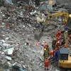 Lực lượng cứu hộ nỗ lực tìm kiếm các nạn nhân bị mắc kẹt trong đống đổ nát. (Nguồn: THX/TTXVN)