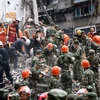Nhân viên cứu hộ nỗ lực tìm kiếm nạn nhân vụ sập nhà tại quận Lộc Thành, thành phố Ôn Châu. (Nguồn: AFP/TTXVN)