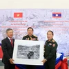 Đại sứ Nguyễn Mạnh Hùng trao tặng ảnh quý cho Bảo tàng lịch sử QĐND Lào. (Ảnh: Phạm Kiên/Vietnam+)