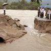 Tuyến đường nối xã Vinh Kim đi Vĩnh Sơn, huyện Vĩnh Thạnh, Bình Định bị nước lũ cuốn trôi một đoạn dài, giao thông bị chia cắt. (Ảnh: Nguyên Linh/TTXVN)