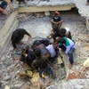 Nhân viên cứu hộ tìm kiếm nạn nhân bị mắc kẹt dưới những đống đổ nát sau trận động đất ở Pidie Jaya, tỉnh Aceh. (Nguồn: AFP/TTXVN)