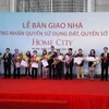 Lần đầu tiên Hà Nội tổ chức bàn giao nhà kèm "sổ đỏ". (Ảnh" Minh Nghĩa/Vietnam+)
