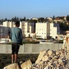 Hai người dân Palestine nhìn về phía khu định cư Do Thái Beit El ở khu Bờ Tây. (Nguồn: AFP​)