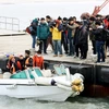 Thân nhân các nạn nhân trong vụ chìm phà Sewol theo dõi quá trình trục vớt ở ngoài khơi đảo Jindo, Hàn Quốc ngày 28/3. (Nguồn: EPA/TTXVN)