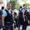  Cảnh sát Pháp áp giải một nghi phạm tại hiện trường vụ tấn công ở Reunion ngày 27/4. (Nguồn: AFP/TTXVN)