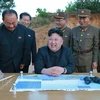  Nhà lãnh đạo Triều Tiên Kim Jong-un (giữa, phía trước) giám sát vụ phóng thử tên lửa đạn đạo đất đối đất kiểu mới Hwasong-12 ngày 14/5. (Nguồn: YONHAP/TTXVN)