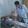 Bác sỹ Bệnh viện Đa khoa tỉnh Bắc Ninh thăm khám cho nạn nhân Nguyễn Thành Đạt. (Ảnh: Diệp Trương/TTXVN)