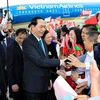 Cán bộ, nhân viên Đại sứ quán Việt Nam và đại diện cộng đồng người Việt Nam tại Cộng hoà Belarus đón Chủ tịch nước Trần Đại Quang và Phu nhân tại sân bay Quốc tế Minsk. (Ảnh: Nhan Sáng/TTXVN)