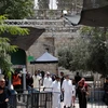 Các tín đồ Hồi giáo đi qua máy dò kim loại tại khu vực lối vào đền thờ Al-Aqsa ở Jerusalem ngày 23/7. (Nguồn: AFP/TTXVN)