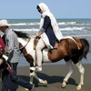 Khách du lịch dạo chơi trên bãi biển ở thành phố cảng Gisum, Iran. (Nguồn: AFP/TTXVN)
