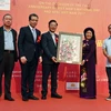 Họa sỹ Văn Dương Thành tặng tranh cho Hội Ngoại giao công chúng Trung Quốc. (Ảnh: Vĩnh Hà/Vietnam+)