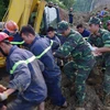 Lực lượng cứu hộ huy động máy xúc chuyên dụng vào xóm Khanh, xã Phú Cường, huyện Tân Lạc để tiếp tục tìm kiếm thi thể nạn nhân còn lại đang bị vùi lấp. (Ảnh: Vũ Hà/TTXVN)