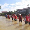 Đoàn cán bộ Chữ thập đỏ tiếp cận vùng lũ lụt. (Ảnh: Khiếu Tư/TTXVN)