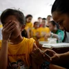 Tiêm vắcxin Dengvaxia phòng bệnh sốt xuất huyết cho học sinh trường tiểu học Parang ở Marikina, phía tây Manila ngày 4/4/2016. (Nguồn: AFP/TTXVN)