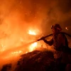 Nhân viên cứu hỏa dập lửa cháy rừng tại Santa Paula, Ventura, Mỹ ngày 5/12. (Nguồn: THX/TTXVN)