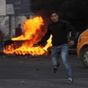 Người biểu tình Palestine ném đá vào binh sỹ Israel tại thành phố Nablus, Khu Bờ Tây ngày 10/12. (Nguồn: THX/TTXVN)