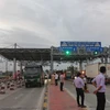 Lái xe tải Bình Định trả tiền lẻ để qua trạm BOT nam Bình Định ngày 14/11. (Ảnh: Phạm Kha/TTXVN)