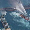 Tàu phòng vệ của Nhật Bản và tàu tuần tra Trung Quốc nỗ lực dập lửa cháy trên tàu Sanchi. (Nguồn: CNN/TTXVN)