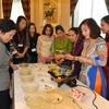Phụ nữ ASEAN thích thú với tiết mục giới thiệu ẩm thực Việt Nam của Phu nhân Công sứ. (Ảnh: Lương Tuấn-Vĩnh 
