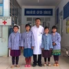 Trưởng khoa Hồi sức-Cấp cứu-Chống độc, Bệnh viện Đa khoa huyện Mèo Vạc chụp ảnh với 4 cháu học sinh sáng 13/4 trước khi 3 cháu được xuất viện. (Ảnh: Minh Tâm/TTXVN)
