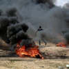  Người Palestine đốt lốp xe trong cuộc biểu tình tại khu vực biên giới Dải Gaza với Israel. (Nguồn: THX/TTXVN)
