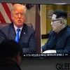 Người dân theo dõi qua truyền hình hình ảnh Tổng thống Mỹ Donald Trump (trái) và Nhà lãnh đạo Triều Tiên Kim Jong-un ngày 24/5. (Nguồn: AFP/TTXVN)