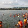 Việc người dân kéo nhau ra sông Đà tắm, bơi lội khá nguy hiểm. (Ảnh: Thanh Hải/TTXVN)