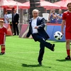 Tổng thống Nga Vladimir Putin (giữa) sút bóng khi ông tham dự lễ khai mạc triển lãm trận đấu bóng đá tại Công viên bóng đá World Cup trên Quảng trường Đỏ ở thủ đô Moskva ngày 28/6. (Ảnh: AFP/TTXVN)