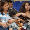 Bà mẹ và trẻ em nhập cư chờ được hỗ trợ bởi các tình nguyện viên tại một trung tâm nhân đạo ở bang Texas, Mỹ ngày 15/6. (Ảnh: AFP/TTXVN)