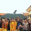 Đại sứ Nguyễn Mạnh Cường, Đại đức Thích Minh Huệ và bà con cộng đồng người Việt thực hiện nghi thức thả chim phóng sinh. (Ảnh: TTXVN)
