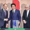 Thủ tướng Nhật Bản Shinzo Abe (giữa), Chủ tịch Hội đồng châu Âu Donald Tusk (trái) và Chủ tịch Ủy ban châu Âu Jean-Claude Juncker (phải) sau lễ ký tại Tokyo. (Ảnh: Kyodo/TTXVN)