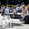Người dân nghỉ ngơi tránh nóng tại đài phun nước quảng trường Tòa thị chính ở trung tâm London, Anh ngày 2/7. (Nguồn: AFP/TTXVN)