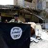  Một thành viên IS giương lá cờ chiến binh Hồi giáo ở thành phố cổ Mosul, Iraq ngày 10/7. (Nguồn: Reuters)