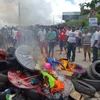 Người dân địa phương ở thị trấn Pacaraima, bang Roraima (Brazil) đốt phá đồ đạc của người di cư Venezuela trong cuộc xung đột ngày 18/8. (Ảnh: AFP/TTXVN)
