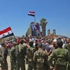 Binh sĩ quân đội chính phủ Syria giương cao quốc kỳ sau khi giải phóng thành phố Quneitra ngày 27/7. (Ảnh: AFP/TTXVN)