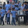 Phát nước uống cho học sinh của một trường học do Cơ quan Liên hợp quốc vì người tị nạn Palestine (UNRWA) quản lý tại Dải Gaza ngày 29/8. (Ảnh: AFP/TTXVN)