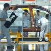 Công nhân làm việc trên dây chuyền lắp ráp ôtô ở Thành Đô, Trung Quốc. (Ảnh: AFP/TTXVN)