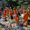 Lực lượng cứu hộ chuyển thi thể nạn nhân ra khỏi đống đổ nát của một tòa nhà bị sập sau thảm họa động đất và sóng thần ở Palu, tỉnh Trung Sulawesi, Indonesia ngày 1/10/2018. (Ảnh: THX/TTXVN)