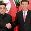 Chủ tịch Trung Quốc Tập Cận Bình (phải) và lãnh đạo Triều Tiên Kim Jong-un bắt tay tại Đại lễ đường Nhân dân ở Bắc Kinh hôm 19/6. (Ảnh: AFP)