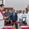Tổng thống Sri Lanka Maithripala Sirisena (phải) chứng kiến lễ tuyên thệ nhậm chức Thủ tướng mới của ông Mahinda Rajapakse (trái) tại Colombo ngày 26/10/2018. (Ảnh: AFP/TTXVN)