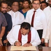 Thủ tướng Sri Lanka Mahinda Rajapakse (giữa) ký đơn từ chức tại Colombo ngày 15/12/2018. (Ảnh: AFP/TTXVN)