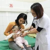Bác sỹ thăm khám cho bệnh nhi bị nhập viện do phản ứng với vắcxin. (Ảnh: Xuân Tư/TTXVN)