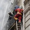 Lực lượng cứu hỏa hỗ trợ người mắc kẹt trong tòa nhà sau vụ nổ ở trung tâm Paris, Pháp ngày 12/1/2019. (Ảnh: AFP/TTXVN)