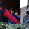 Các đặc vụ liên bang hộ tống cư dân từ một căn hộ ở Rowland Heights trong cuộc đột kích điều tra "du lịch sinh con" năm 2015. (Nguồn: Los Angeles Times)