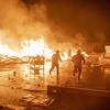 Lính cứu hỏa nỗ lực dập lửa do người biểu tình gây ra trong cuộc bạo loạn tại thủ đô Port-au-Prince, Haiti, ngày 16/2/2019. (Ảnh: EFE/TTXVN)
